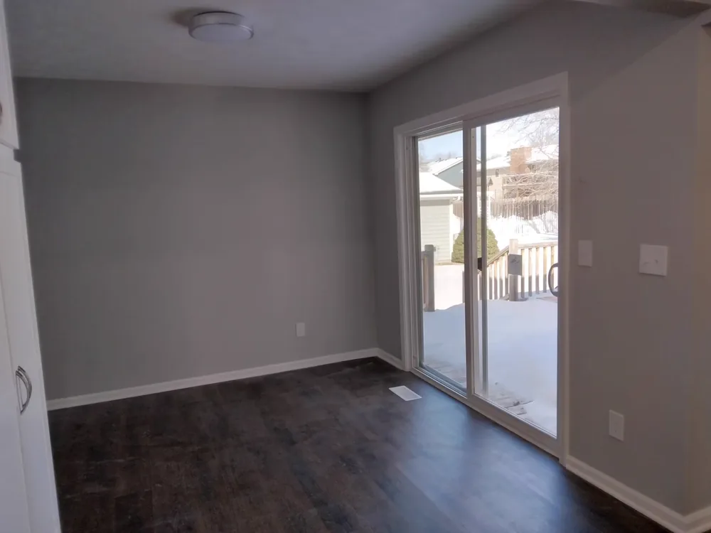 Living space with dark wood-look luxury vinyl plank flooring and patio doors