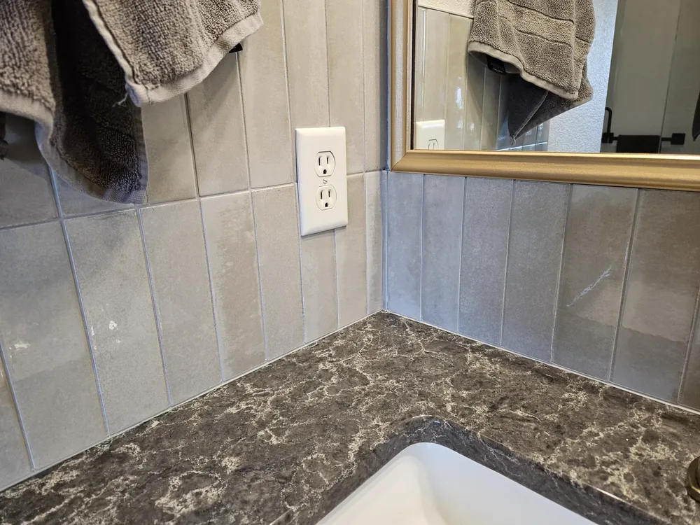 Vertical stacked wall tile and stone countertop detail in a bathroom remodel