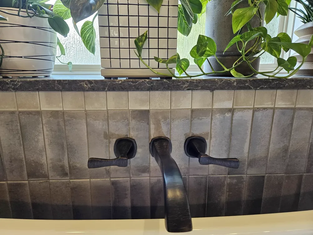 Wall-mounted faucet against textured tile in a Salina bathroom project